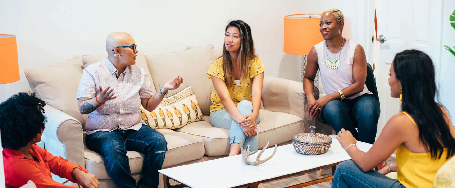 Group of adults engaged in a casual conversation in a Sherman Oaks living room setting.